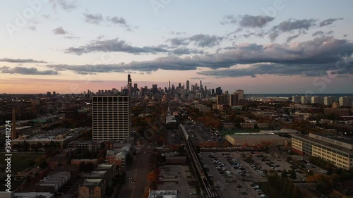 Incredible aerial view of the Chicago city skyline at sunset from the south side with the expressway and residential buildings littering the landscape below and pink and blue clouds above.