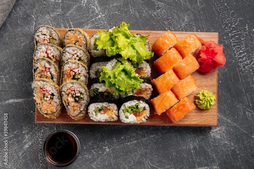 Top view on sushi roll assorted set on the wooden board with soy sauce