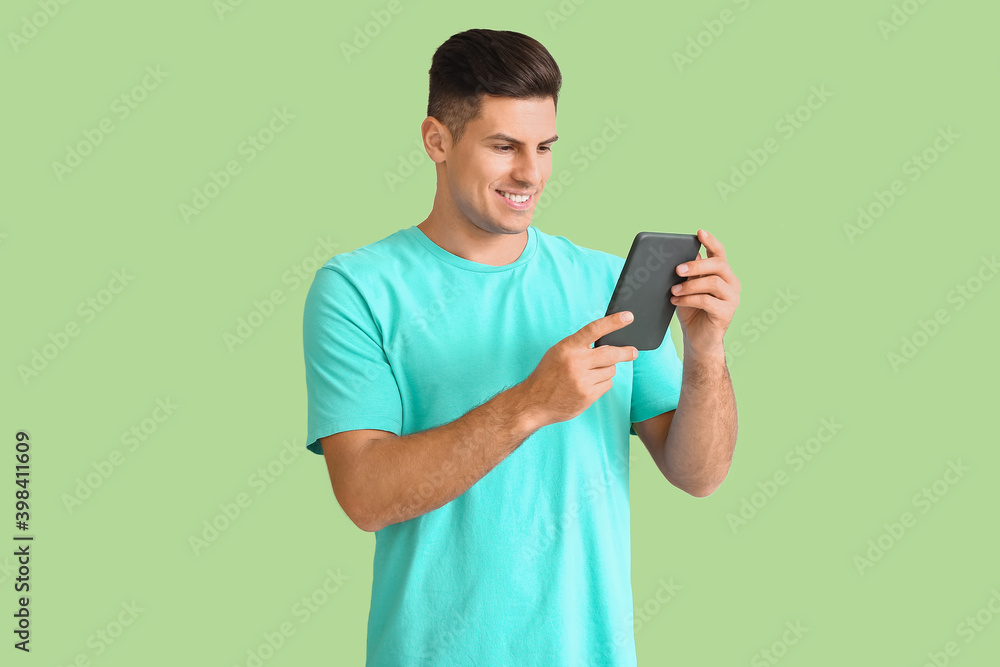 Young man with e-reader on color background Young man with e-reader on color background