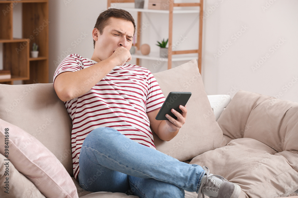 Young man reading boring e-book at home Young man reading boring e-book at home
