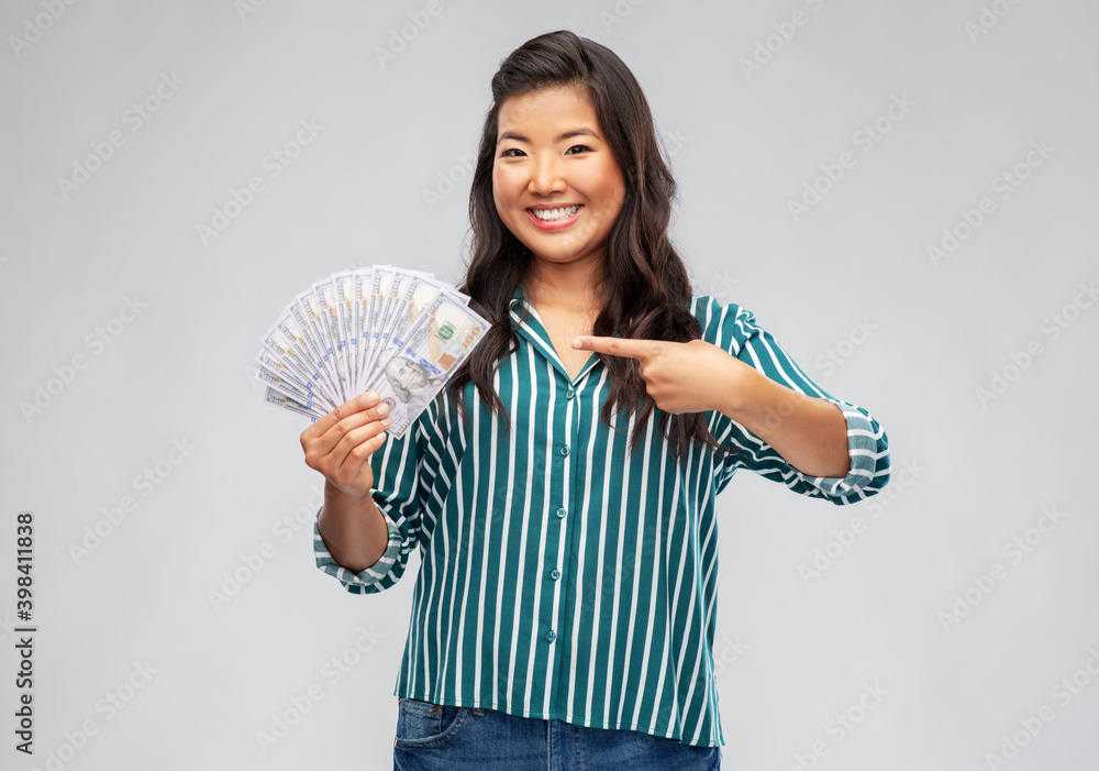 people, ethnicity and portrait concept - happy asian young woman holding hundreds of dollar money banknotes over grey background people, ethnicity and portrait concept - happy asian young woman holding hundreds of dollar money banknotes over grey background