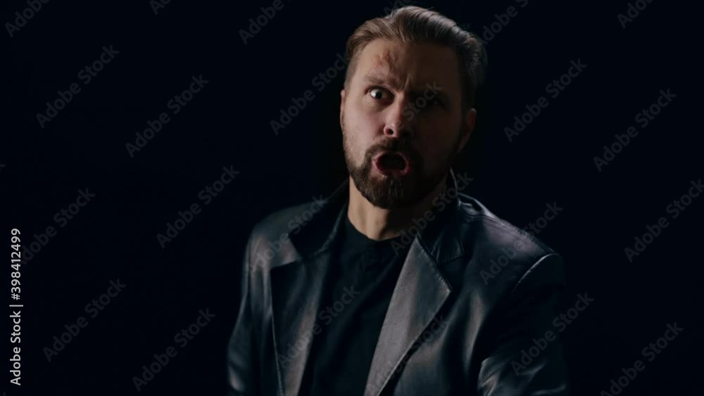 Emotional bad guy in black jacket yelling and gesturing over black