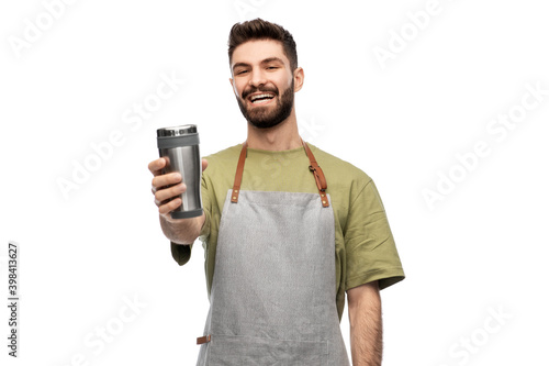 people, profession and job concept - happy smiling waiter in apron holding tumbler or takeaway thermo cup over white background