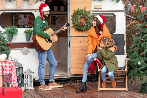 Happy family with guitar ou...