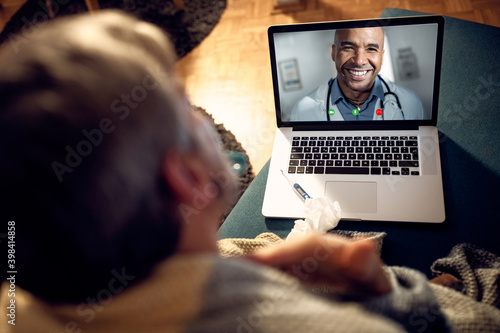 Fototapeta Naklejka Na Ścianę i Meble -  Close-up of happy doctor talking to his patient via video call at night.