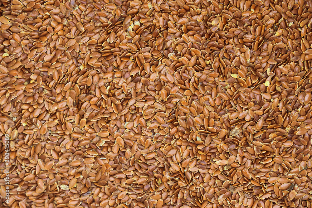 Linum usitatissimum, brown flax seeds background. Flaxseed texture