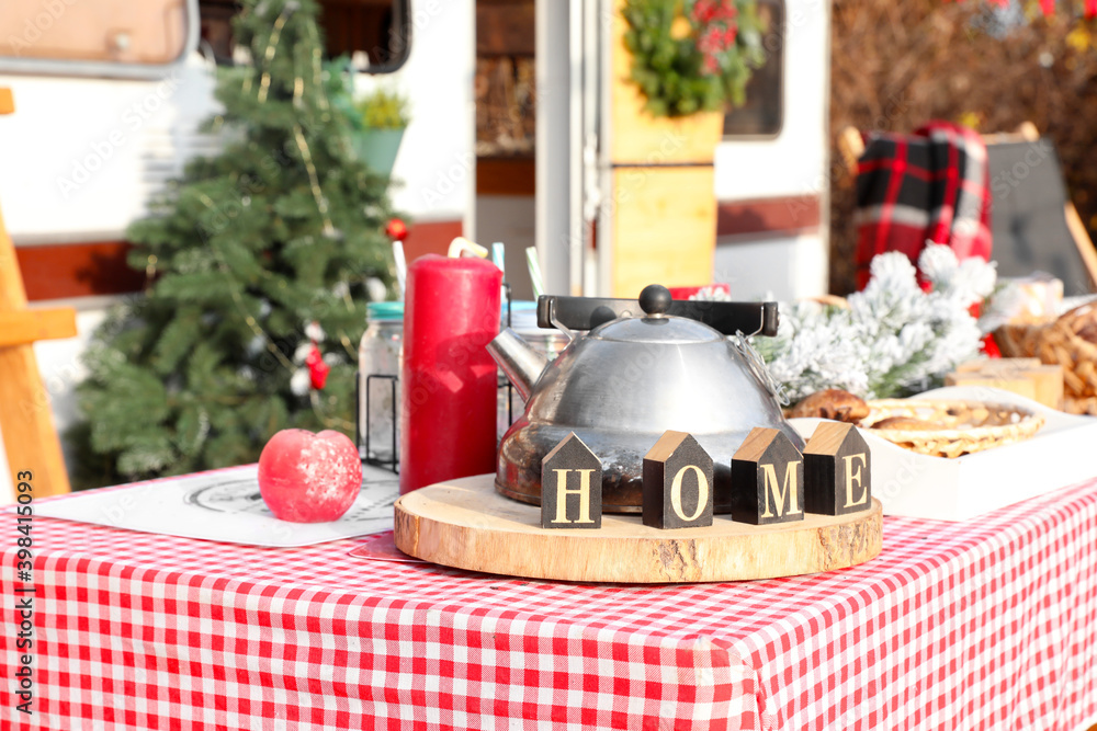 Naklejka premium Table set for Christmas celebration outdoors near motorhome