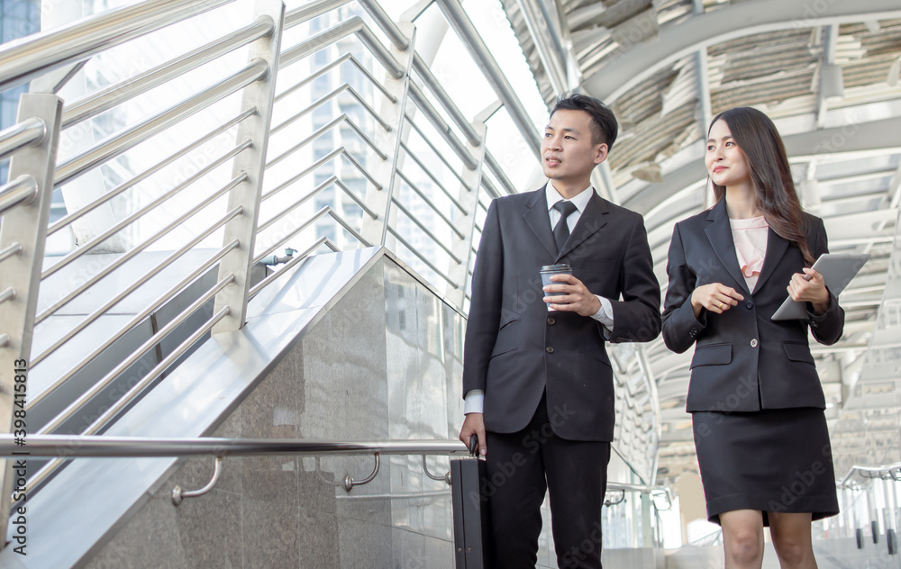 Two business man and woman talking and walking outside Two business man and woman talking and walking outside