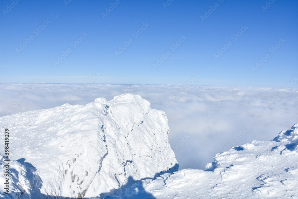 Winter mountain. Snowy peak high above the clouds. Show and clouds on Dry Mountain, Serbia Winter mountain. Snowy peak high above the clouds. Show and clouds on Dry Mountain, Serbia