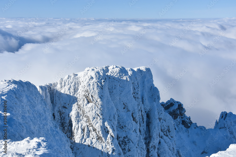 Winter mountain. Snowy peak high  above the clouds. Show and clouds on Dry Mountain, Serbia