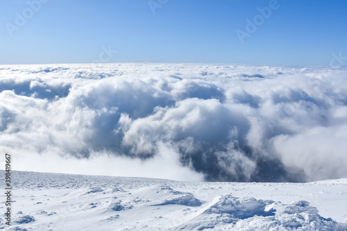 Winter mountain. Snowy peak high above the clouds. Show and clouds on Dry Mountain, Serbia