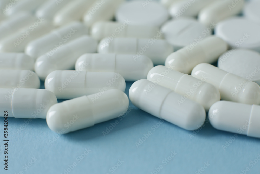 White pills on blue background White pills on blue background