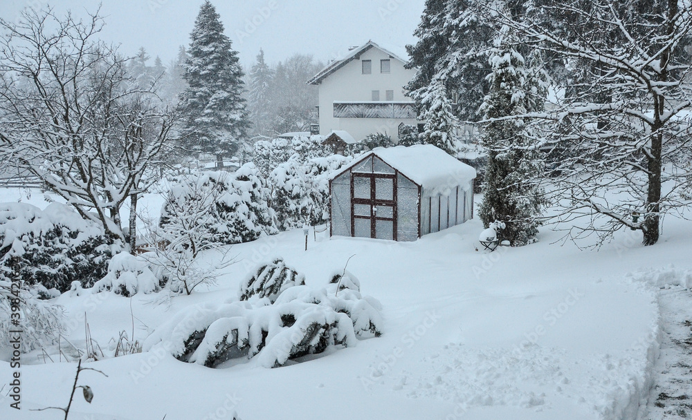 Gewächshaus im Garten mit viel Schnee eingeschneit Wintergarten Winter