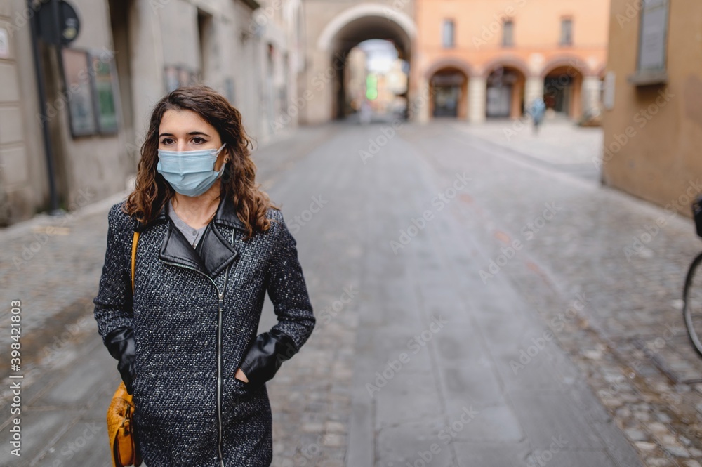 Copy space close-up portrait caucasian young woman walking in a city center during cold winter season. Lady wearing a protective face mask. Pandemic, new normal concept. Copy space close-up portrait caucasian young woman walking in a city center during cold winter season. Lady wearing a protective face mask. Pandemic, new normal concept.