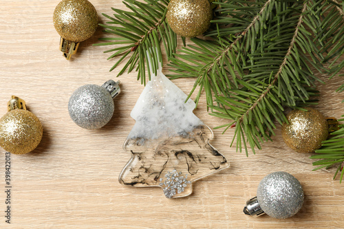 Pine branches and Christmas baubles on wooden background