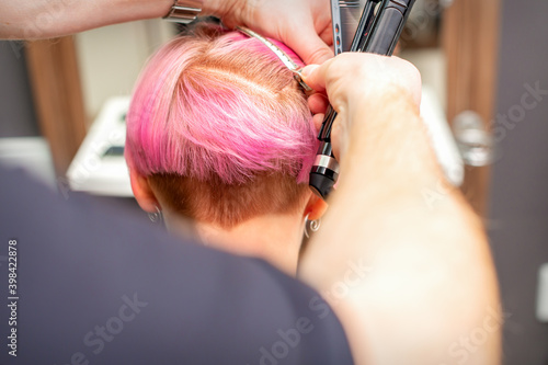 Hairdresser pinches hair with the clip before doing hairstyle in a hair salon