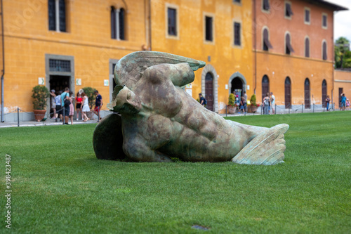 Sculpture of Fallen angel (Angelo caduto) on the lawn in the grass, Pisa, Italy