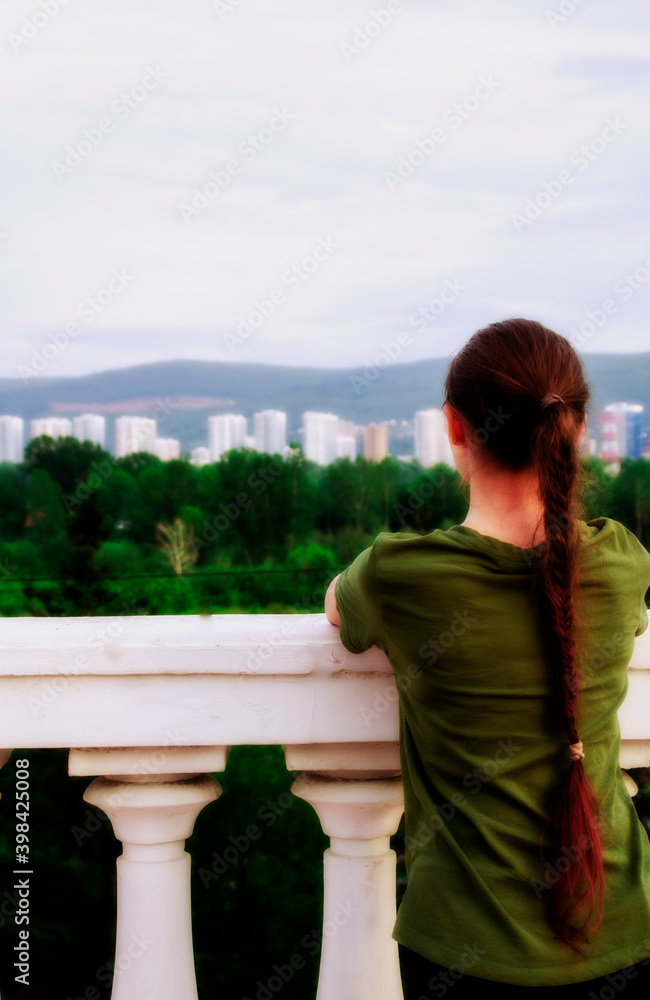 The girl looks into the distance. Russia, the city of Krasnoyarsk