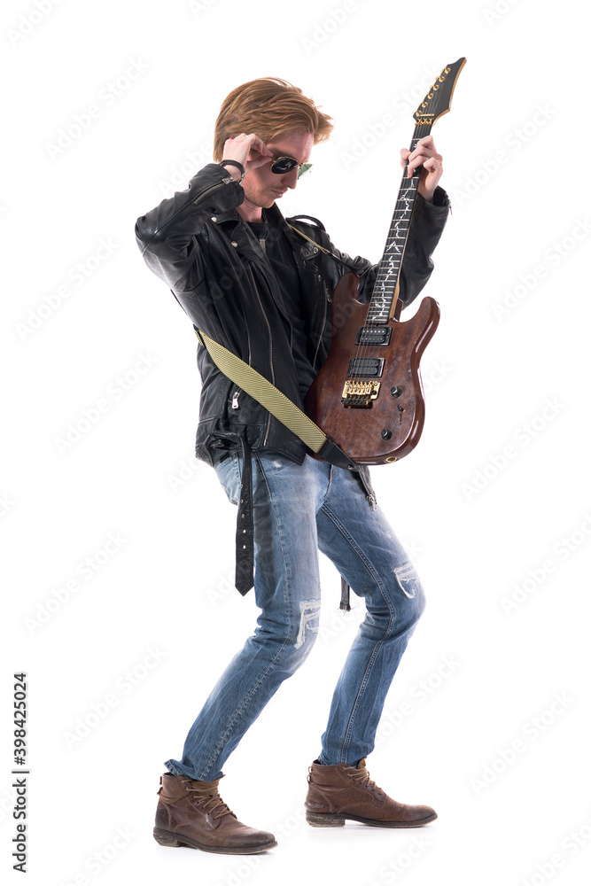 Rock musician young handsome man preparing for concert checking his electric guitar. Full body length isolated on white background. Rock musician young handsome man preparing for concert checking his electric guitar. Full body length isolated on white background.