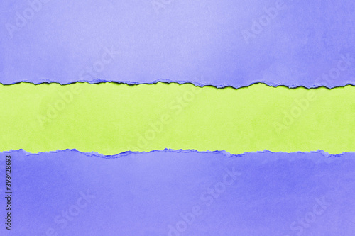 Natural background of torn blue textured paper on background of green.