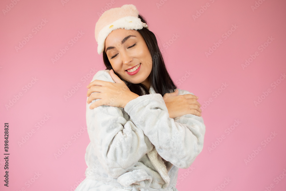Portrait of a pretty young woman in sleeping clothes hugging herself. Concept of selfish emotion. Portrait of a pretty young woman in sleeping clothes hugging herself. Concept of selfish emotion.