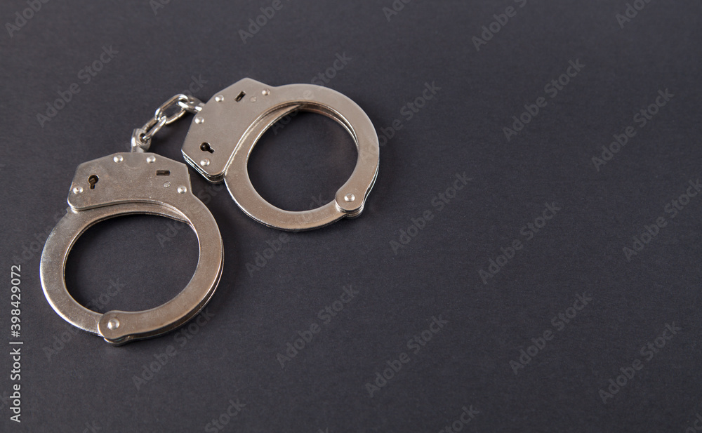 Metal handcuffs on an isolated black background. Metal handcuffs on an isolated black background.