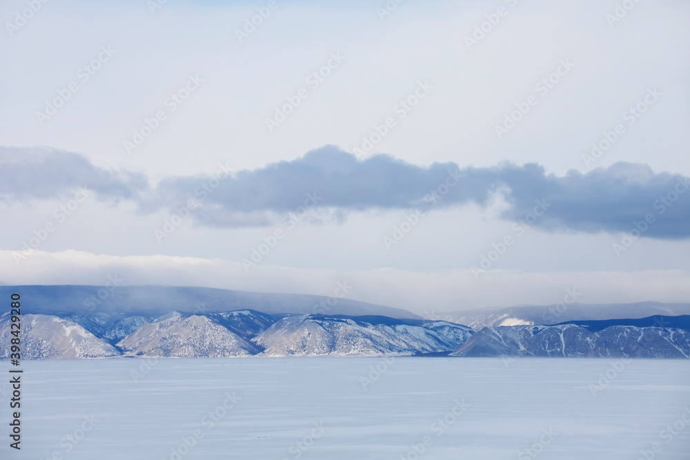 Winter landscape. Baikal lake. Snowy mountain peaks