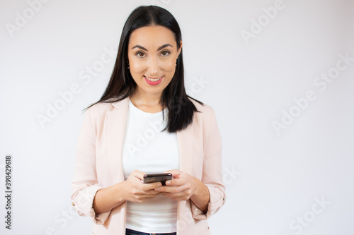 Portrait of a happy young business woman using mobile phone isolated over white background