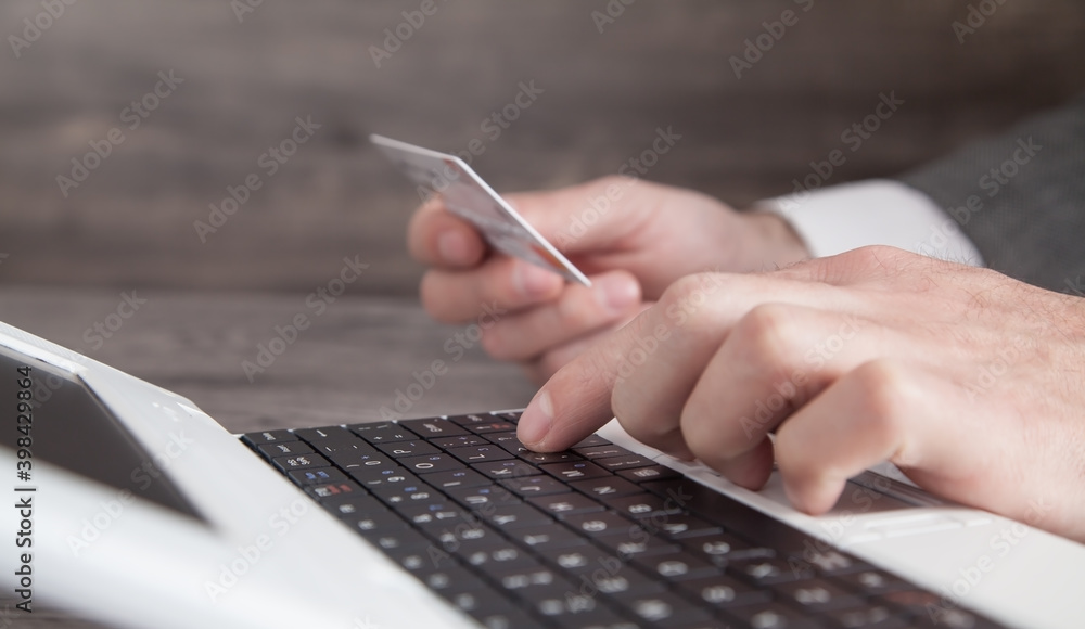 Businessman holding credit card and using laptop. Businessman holding credit card and using laptop.