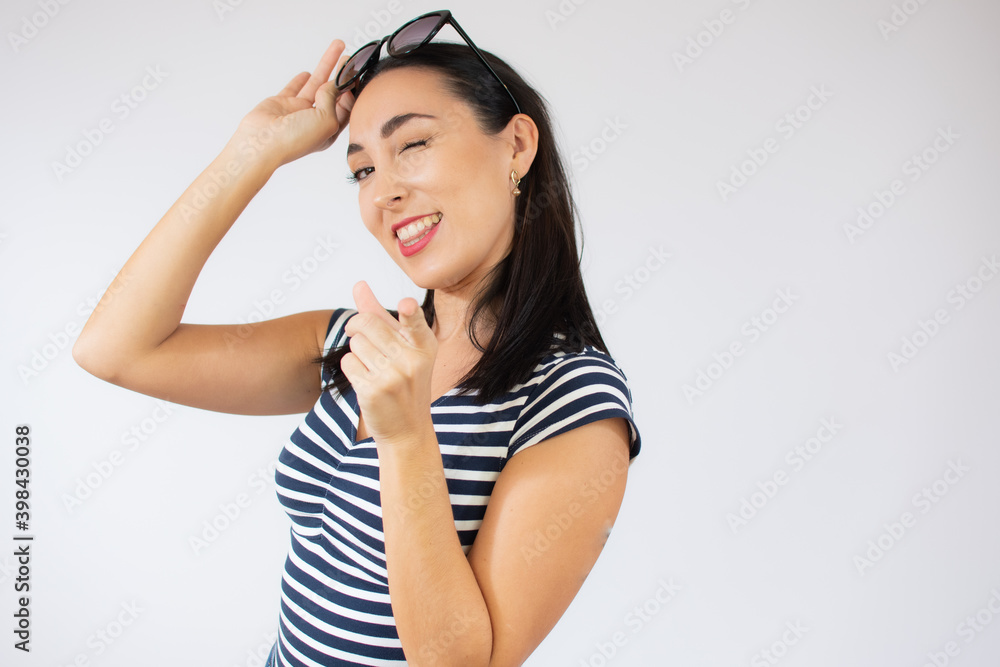 Fashion portrait of young happy woman wearing striped t-shirt over white background. Fashion portrait of young happy woman wearing striped t-shirt over white background.
