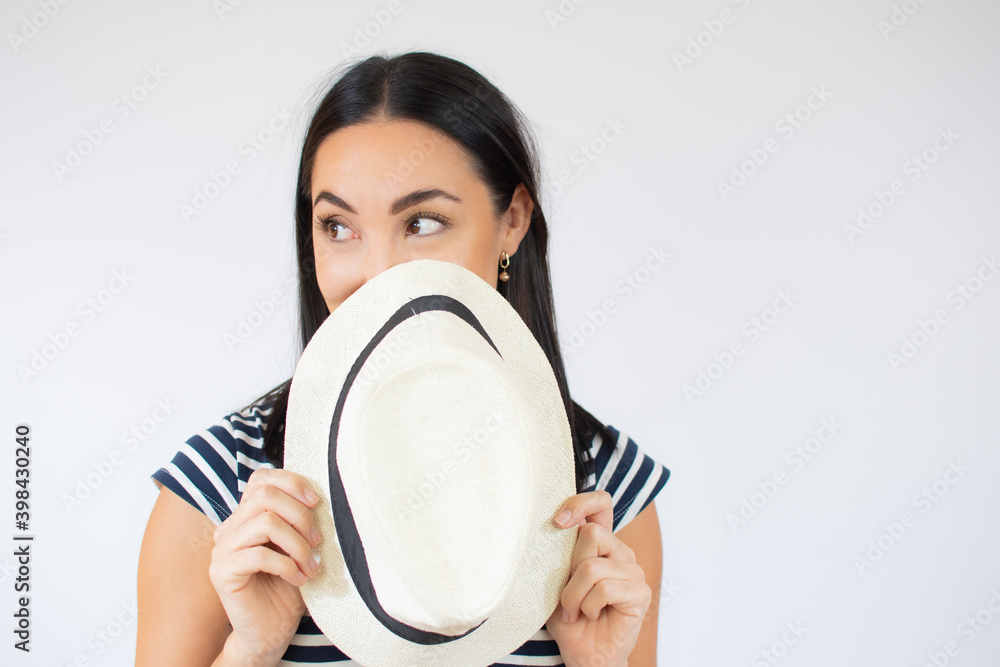Young beautiful woman covering her mouth with a straw hat over white background. Young beautiful woman covering her mouth with a straw hat over white background.