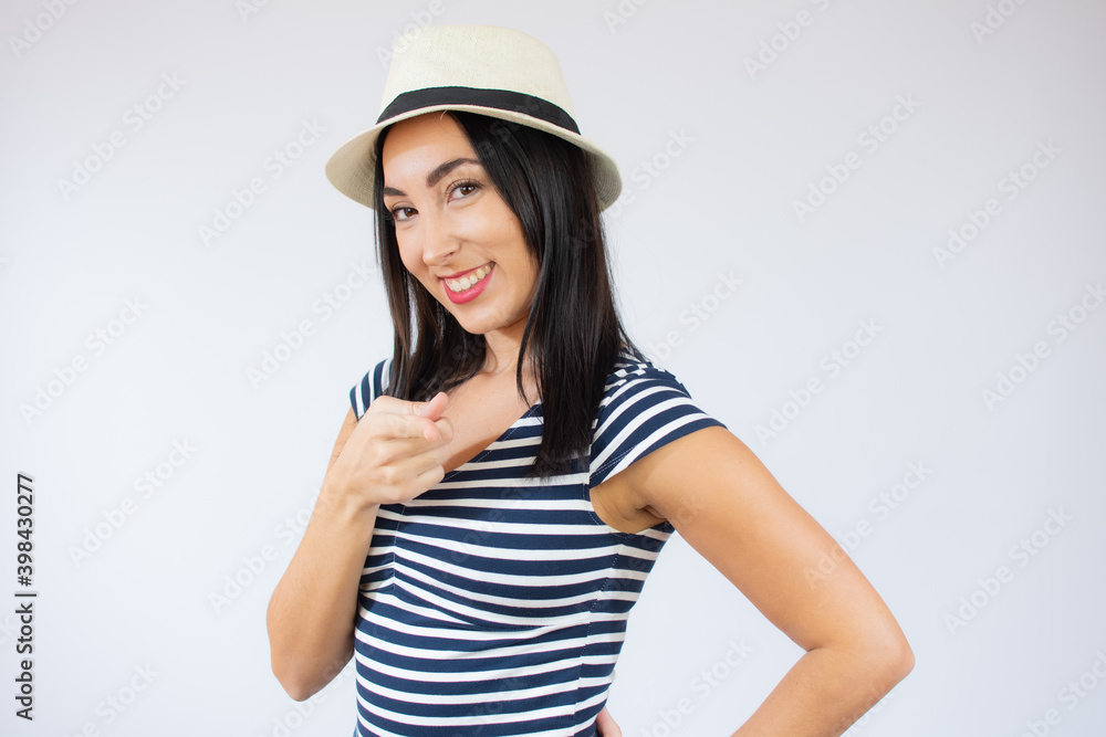Young beautiful woman wearing straw hat and striped t-shirt smiling over white background. Young beautiful woman wearing straw hat and striped t-shirt smiling over white background.