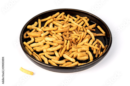 An isolated image of a pile of some bread sticks or cracker sticks on a plate on a white plate or table top. Spicy appetizer close-up image on a white background.