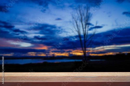 Blurred blue autumn background at lake with wooden table empty for concept 
