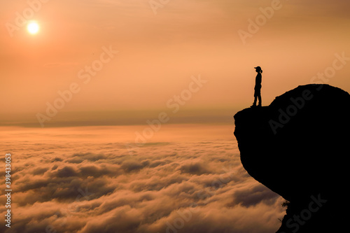 The silhouette of the mountain girl in the sunrise and the fog