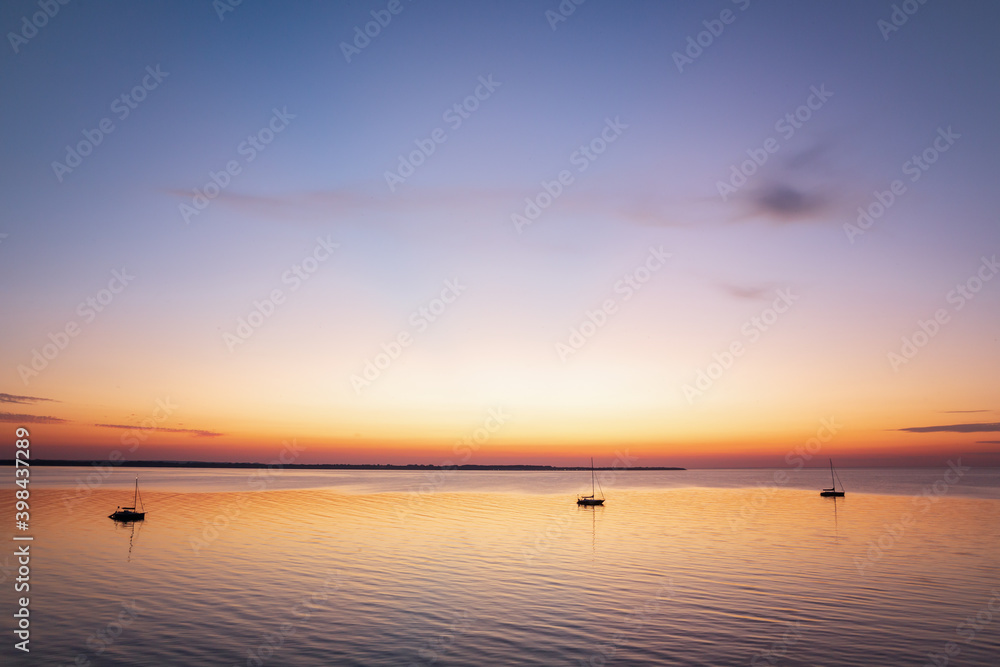 Boats anchored in a peaceful bay after sunset at the Baltic Sea