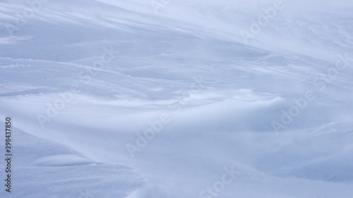 A mountain slope covered with a layer of snow.