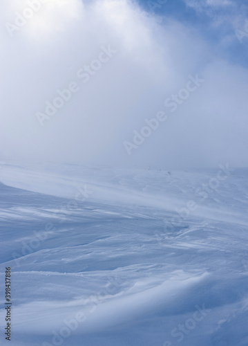 A mountain slope covered with a layer of snow.