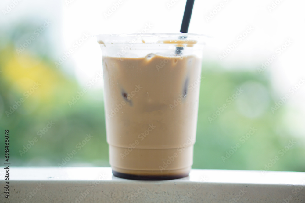 Iced coffee in a plastic cup with a straw that is still half a glass on the table Iced coffee in a plastic cup with a straw that is still half a glass on the table