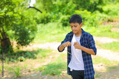 Cute indian little child playing Lattu, Bhovra or Bambaram is a traditional throwing top using thread, played mainly in India photo