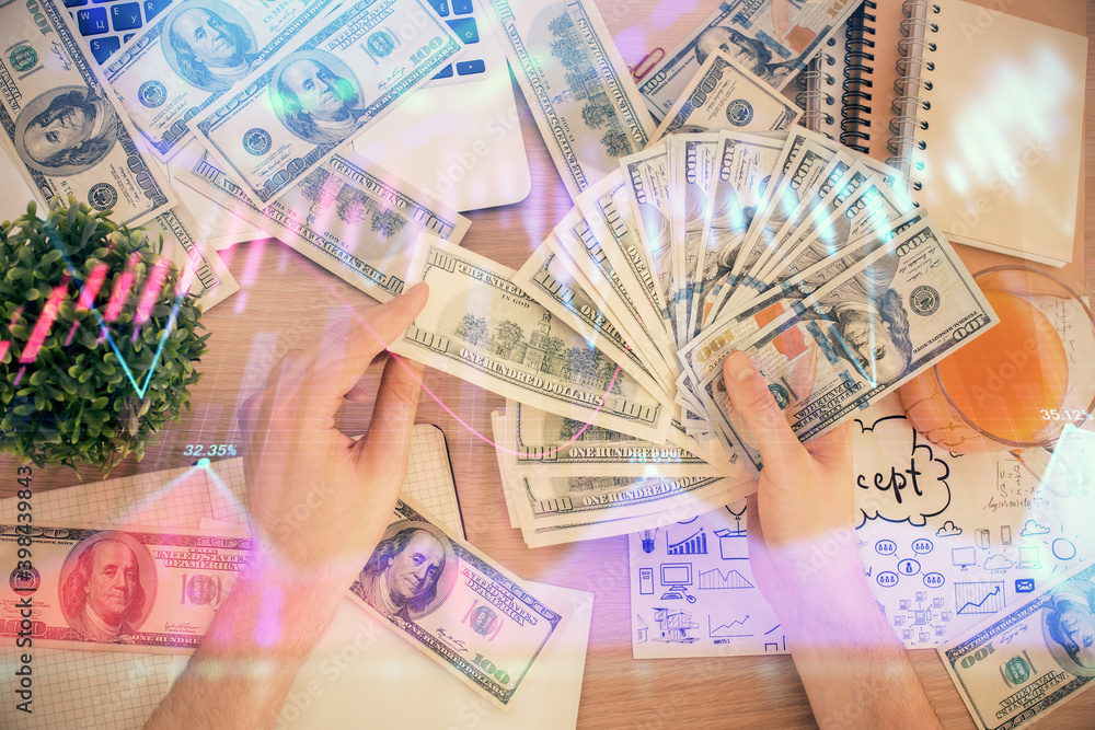 Multi exposure of financial graph drawing hologram and USA dollars bills and man hands. Analysis concept.
