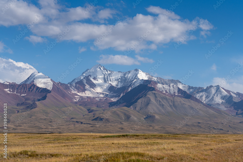 View of snow-capped Trans-Alai or Trans-Alay mountain range in Sary Tash valley, Kyrgyzstan with pasture foreground along the Pamir Highway