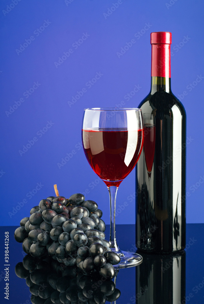 Fototapeta premium Glass and bottle of wine on bright color background