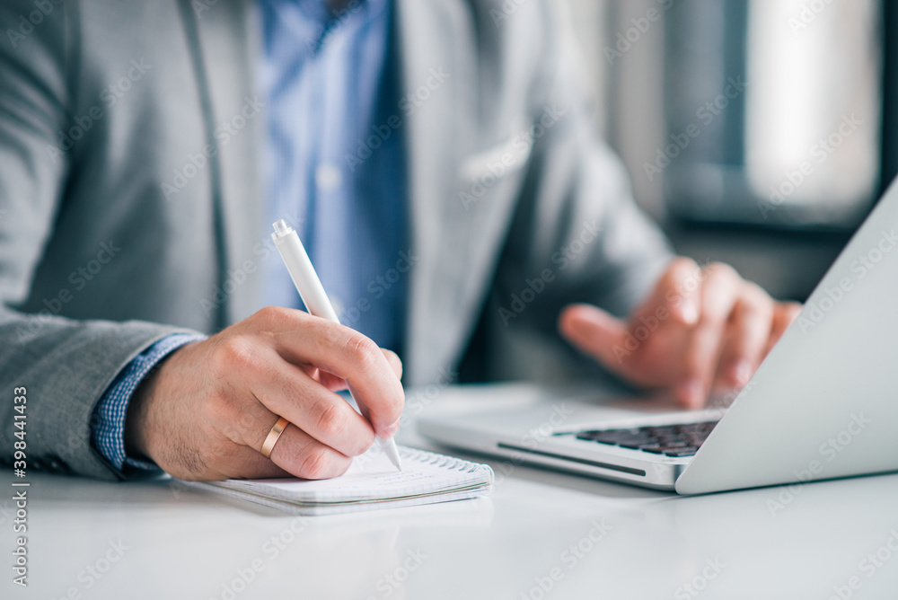 Fototapeta premium Businessman planning work, writing notes in the office.