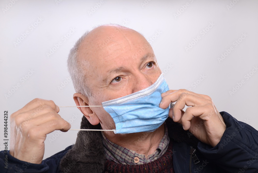 Senior man wearing protective mask over gray background Senior man wearing protective mask over gray background