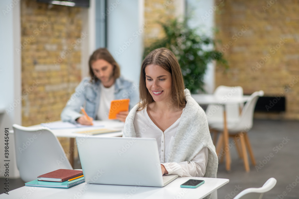 Young man and woman sitting at the tables and studying Young man and woman sitting at the tables and studying