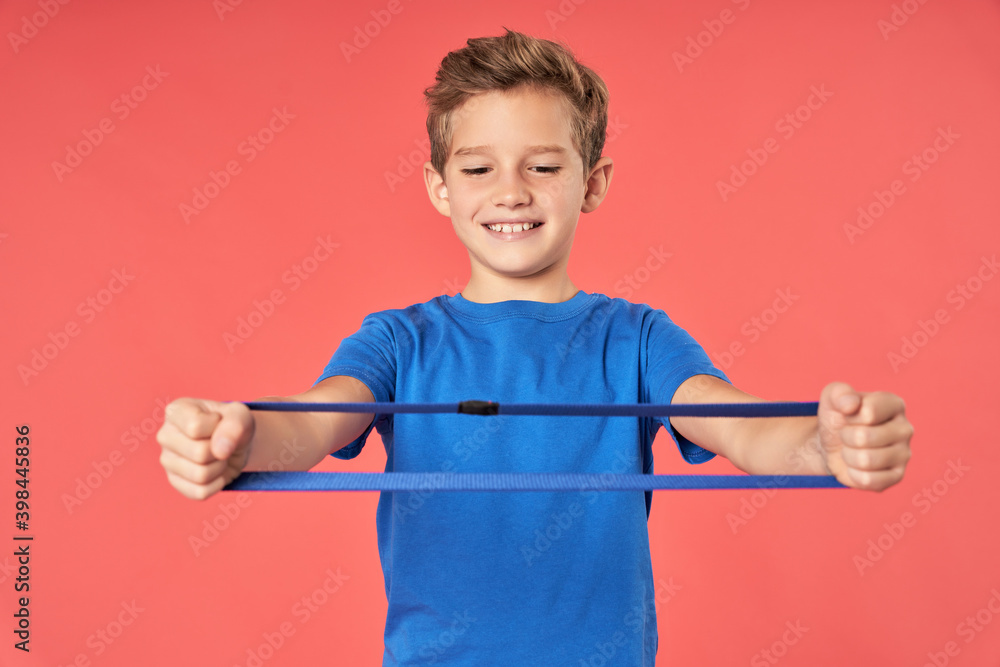 Cheerful boy doing exercise with elastic fitness band Cheerful boy doing exercise with elastic fitness band