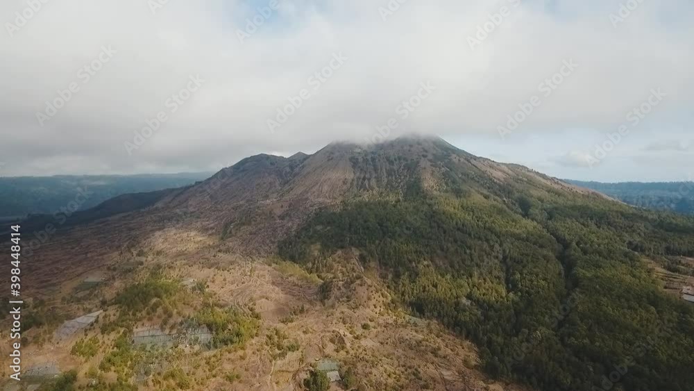 Mountain landscape with volcano, sky with clouds. Aerial view of Mount Batur Volcano in Kintamani. Bali volcano, also referred to as Kintamani is popular sightseeing destination in Bali. Travel Mountain landscape with volcano, sky with clouds. Aerial view of Mount Batur Volcano in Kintamani. Bali volcano, also referred to as Kintamani is popular sightseeing destination in Bali. Travel