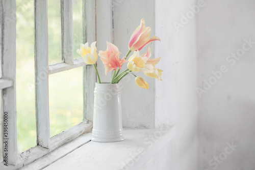 beautiful tulips in vase on white windowsill