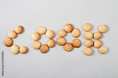A pattern of small pancakes. inscription cook from orange toasted round biscuits. home bakery